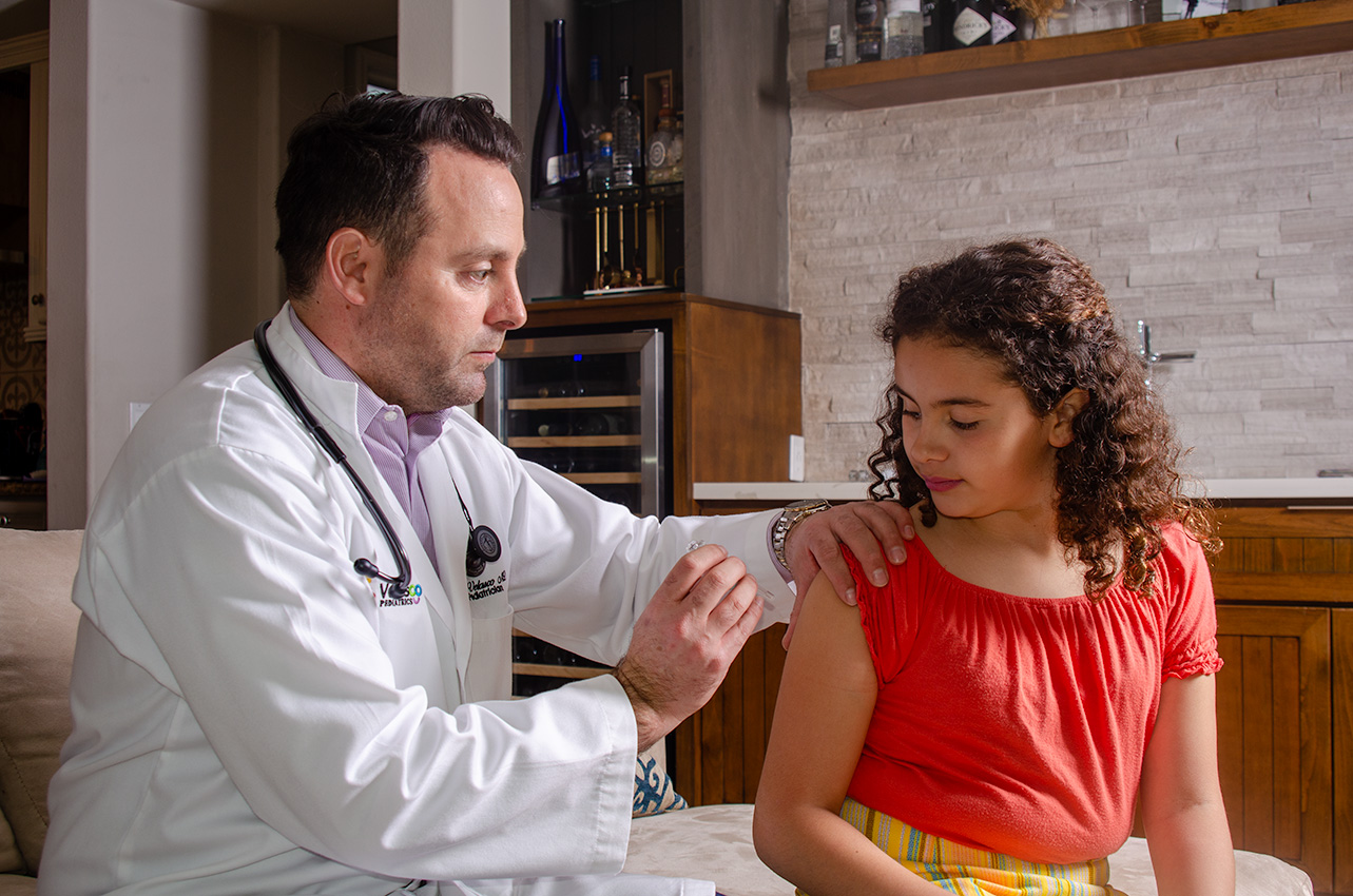 Dr. Victor Velasco examining a young patient at home