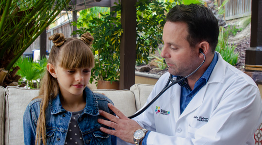 Dr. Velasco listening to a child’s heart